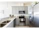 Well-equipped kitchen boasts stainless steel appliances, including a range, microwave, and refrigerator, complemented by granite countertops at 1788 Coriander Dr, Kissimmee, FL 34759