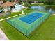 Aerial view of a well-maintained tennis court surrounded by lush landscaping at 1788 Coriander Dr, Kissimmee, FL 34759