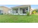 Spacious backyard with screened patio, lush lawn, and a low brick wall at 3151 Riachuelo Ln, Kissimmee, FL 34744