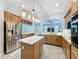 Spacious kitchen with an island, stainless steel fridge, and modern lighting fixtures at 3301 Buckingham Way, St Cloud, FL 34772