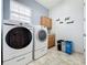 Functional laundry room with modern washer and dryer, storage cabinets, and tiled floor at 3301 Buckingham Way, St Cloud, FL 34772