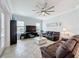 Cozy living room featuring tile floors, a ceiling fan, and comfortable leather furniture at 3301 Buckingham Way, St Cloud, FL 34772