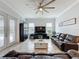 Open concept living room with large windows, tiled floors, and comfortable leather seating at 3301 Buckingham Way, St Cloud, FL 34772