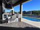 Outdoor bar area by the pool, featuring seating, a mini fridge, and a mounted television at 3301 Buckingham Way, St Cloud, FL 34772