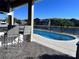 View of the pool area, featuring a pool overlooking the lake, seating and an outdoor bar at 3301 Buckingham Way, St Cloud, FL 34772