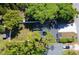 Aerial view featuring a home with a dark roof, manicured lawn, and mature trees at 5255 Seminole Ave, Winter Park, FL 32792