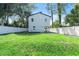 Spacious backyard featuring a lush lawn, white fence and rear of home at 5255 Seminole Ave, Winter Park, FL 32792