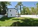 Secluded backyard featuring a well-maintained lawn, white fencing, brick patio, and a charming fire pit at 5255 Seminole Ave, Winter Park, FL 32792