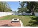 Secluded backyard featuring a well-maintained lawn, white fencing, brick patio, and a charming fire pit at 5255 Seminole Ave, Winter Park, FL 32792