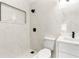 Sleek modern bathroom featuring white marble tile, black fixtures, and a built-in shower niche at 5255 Seminole Ave, Winter Park, FL 32792
