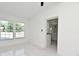 Sunlit bedroom featuring large windows and a glimpse into the updated kitchen at 5255 Seminole Ave, Winter Park, FL 32792