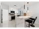 Bright kitchen featuring a breakfast bar, white marble countertops, sleek black hardware, and stainless steel appliances at 5255 Seminole Ave, Winter Park, FL 32792