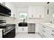 Bright kitchen boasts white cabinetry, stainless steel appliances and a modern black farmhouse sink at 5255 Seminole Ave, Winter Park, FL 32792