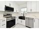 Modern kitchen with stainless steel appliances, white cabinetry, and a black farmhouse sink at 5255 Seminole Ave, Winter Park, FL 32792
