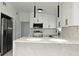 Modern kitchen with stainless steel appliances, black accents, and sleek white cabinets at 5255 Seminole Ave, Winter Park, FL 32792