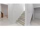 Clean white staircase with wood treads and marble floors, bathed in natural light at 5255 Seminole Ave, Winter Park, FL 32792