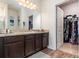 Bathroom vanity with dark wood cabinets and a doorway to the walk-in closet at 538 Stowers Dr, New Smyrna Beach, FL 32168