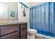 Cozy bathroom featuring a vanity with dark wood cabinets and a shower with blue curtains at 538 Stowers Dr, New Smyrna Beach, FL 32168