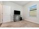 Bedroom showcasing a TV, desk, and a bright window with blinds at 538 Stowers Dr, New Smyrna Beach, FL 32168