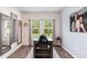 Minimalist dining room featuring a table, two windows with blinds, wood-look flooring, and wall decor at 538 Stowers Dr, New Smyrna Beach, FL 32168