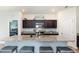 A kitchen featuring granite countertops, dark cabinets, and a breakfast bar with seating for four at 538 Stowers Dr, New Smyrna Beach, FL 32168