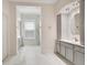 Elegant bathroom featuring marble floors, a vanity with gray cabinets, and a window with modern blinds at 1131 Fern Ave, Orlando, FL 32814