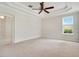 Bedroom with tray ceiling, neutral carpet, and abundant natural light at 1131 Fern Ave, Orlando, FL 32814