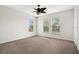 Bright bedroom with three windows, a ceiling fan, and light carpet, offering a serene living space at 1131 Fern Ave, Orlando, FL 32814