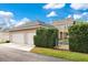 A Two-car garage beside the residence, with a glimpse of the backyard pool through the privacy hedges at 1131 Fern Ave, Orlando, FL 32814