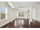 Open living room with columns, dark hardwood floors, tray ceilings, elegant chandeliers, and bright windows at 1131 Fern Ave, Orlando, FL 32814