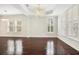 Open living room with dark hardwood floors, tray ceilings, elegant chandeliers, and bright windows at 1131 Fern Ave, Orlando, FL 32814