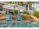 Relaxing pool area with in-water seating and an umbrella for shade, creating a tranquil oasis at 1131 Fern Ave, Orlando, FL 32814