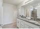 Bathroom with double vanity featuring granite countertop, white cabinets, and tiled shower at 1656 Aspen Ave, Davenport, FL 33837