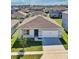 Single-story home with gray exterior, two-car garage, and landscaped lawn at 1656 Aspen Ave, Davenport, FL 33837