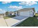 Exterior of a charming home with a two-car garage and freshly manicured lawn at 1656 Aspen Ave, Davenport, FL 33837