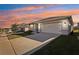 House exterior at sunset with driveway and front yard at 1656 Aspen Ave, Davenport, FL 33837