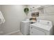 Functional laundry room with washer, dryer, and convenient shelving at 1656 Aspen Ave, Davenport, FL 33837