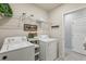 Well-organized laundry room featuring a washer, dryer, shelving, and stylish decor at 1656 Aspen Ave, Davenport, FL 33837