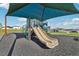 Community playground featuring a slide, swings and other outdoor activities covered by a canopy for sun protection at 1656 Aspen Ave, Davenport, FL 33837