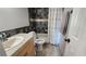 Bathroom with tub shower combo, wood vanity, and tiled walls at 1724 Silver Creek Ct # 105, Orlando, FL 32807