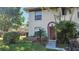 Two-story condo with red door, landscaping, and walkway at 1724 Silver Creek Ct # 105, Orlando, FL 32807