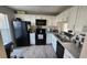 Modern kitchen with white cabinets and black appliances at 1724 Silver Creek Ct # 105, Orlando, FL 32807