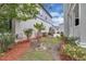 Backyard with lush greenery, mulched garden beds, and a white pergola at 3929 Corrine Dr, Orlando, FL 32814