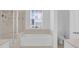 Bright bathroom with a soaking tub, shower, toilet, and window with natural light at 3929 Corrine Dr, Orlando, FL 32814
