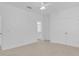 A spacious bedroom featuring a walk-in closet, neutral carpet, and doorway view of the bathroom at 3929 Corrine Dr, Orlando, FL 32814