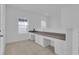 Well-lit hallway features built-in desk with white cabinets and neutral carpet, ideal for work or study at 3929 Corrine Dr, Orlando, FL 32814