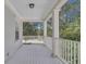 Covered porch with white columns and railing, offering a charming outdoor space with views of lush greenery at 3929 Corrine Dr, Orlando, FL 32814