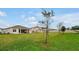 Large backyard featuring well-maintained lawn with shade trees and rear view of home at 4223 Sunset Preserve Blvd, Orlando, FL 32820