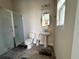 Bright bathroom featuring a shower, toilet, and a pedestal sink with an oval mirror, complemented by light fixtures at 4223 Sunset Preserve Blvd, Orlando, FL 32820