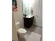 Well-lit bathroom features a modern vanity, toilet, and framed art, finished with neutral tile flooring at 4223 Sunset Preserve Blvd, Orlando, FL 32820